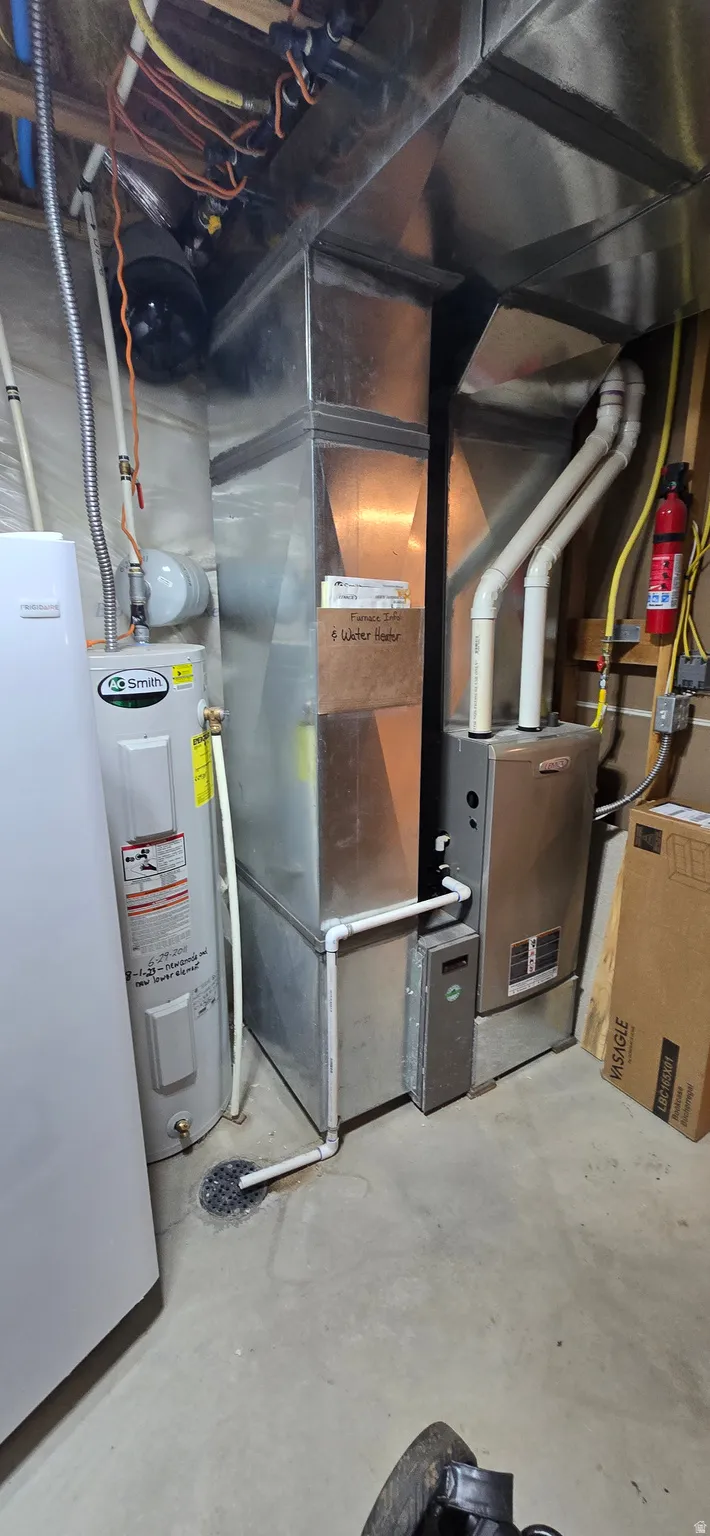 Utility room featuring water heater and heating unit
