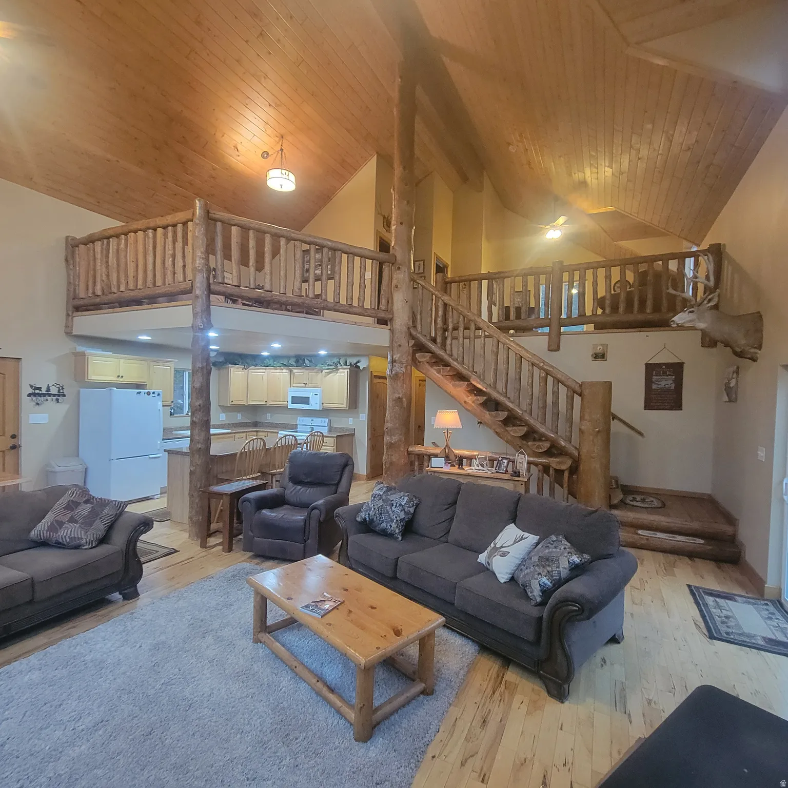 Living room featuring a high wood beamed ceiling and light wood-type flooring