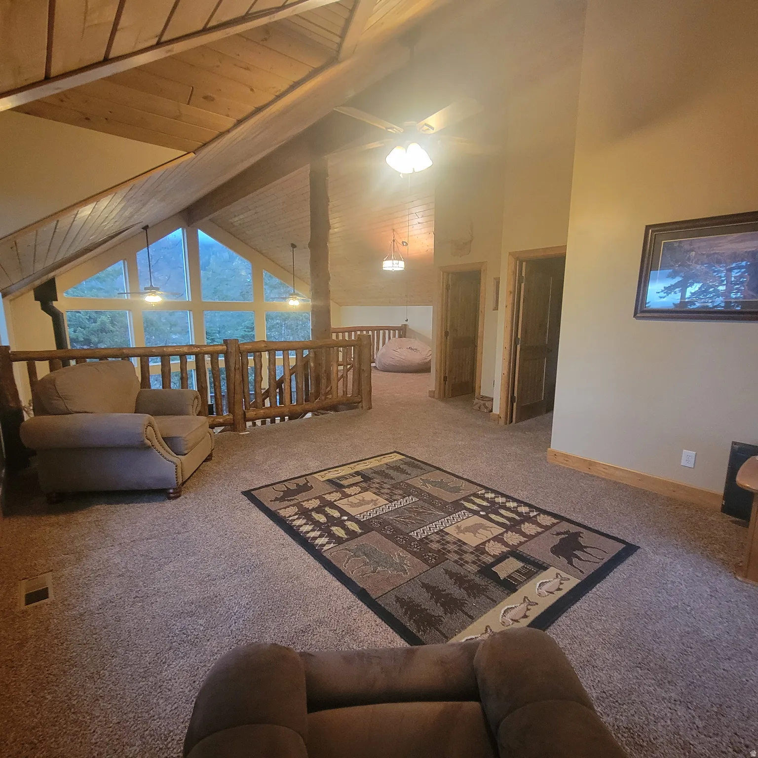 Living room with carpet floors and a high wooden beamed ceiling