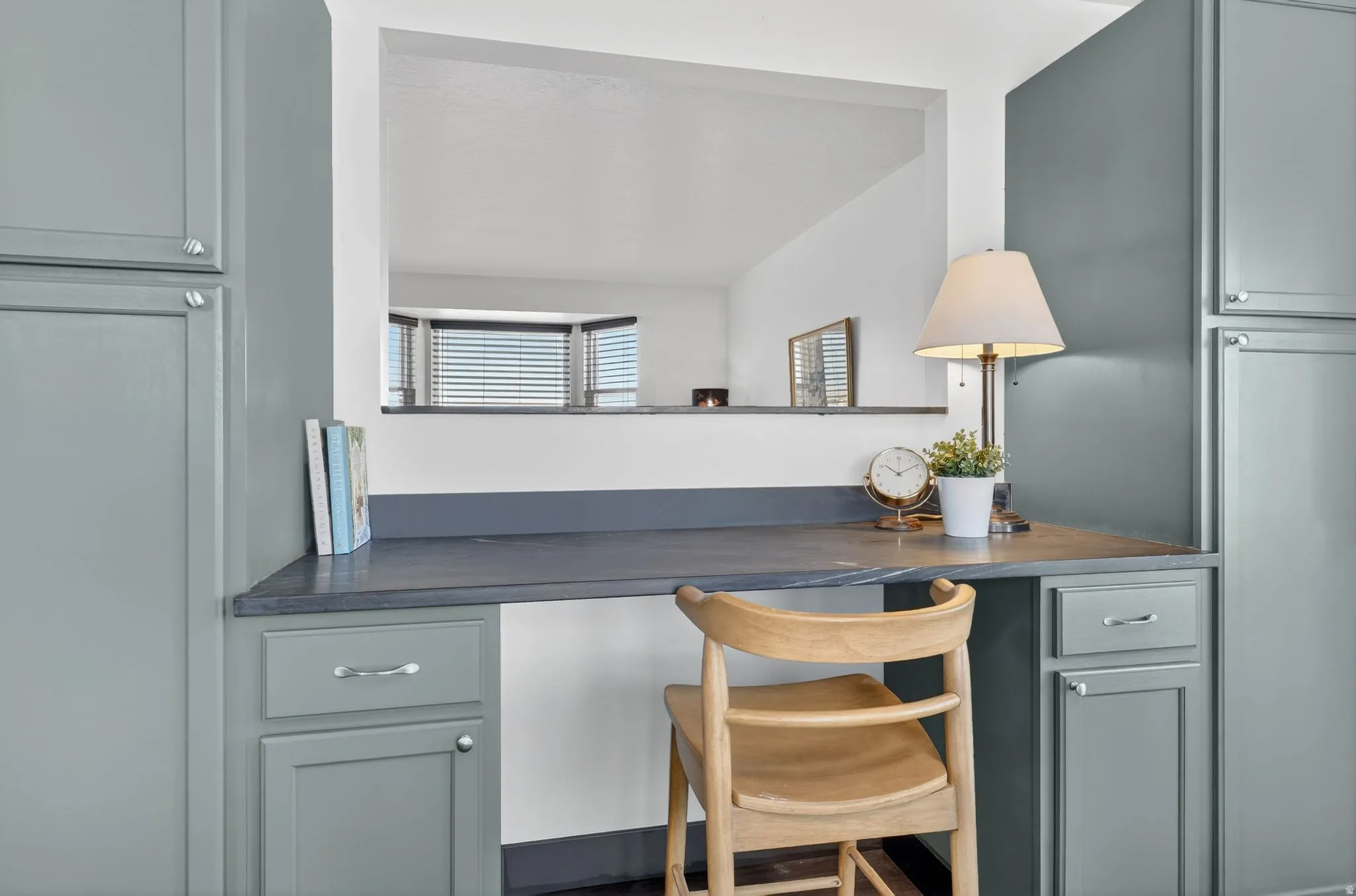 Bar area featuring dark countertops, built in desk, and gray cabinets