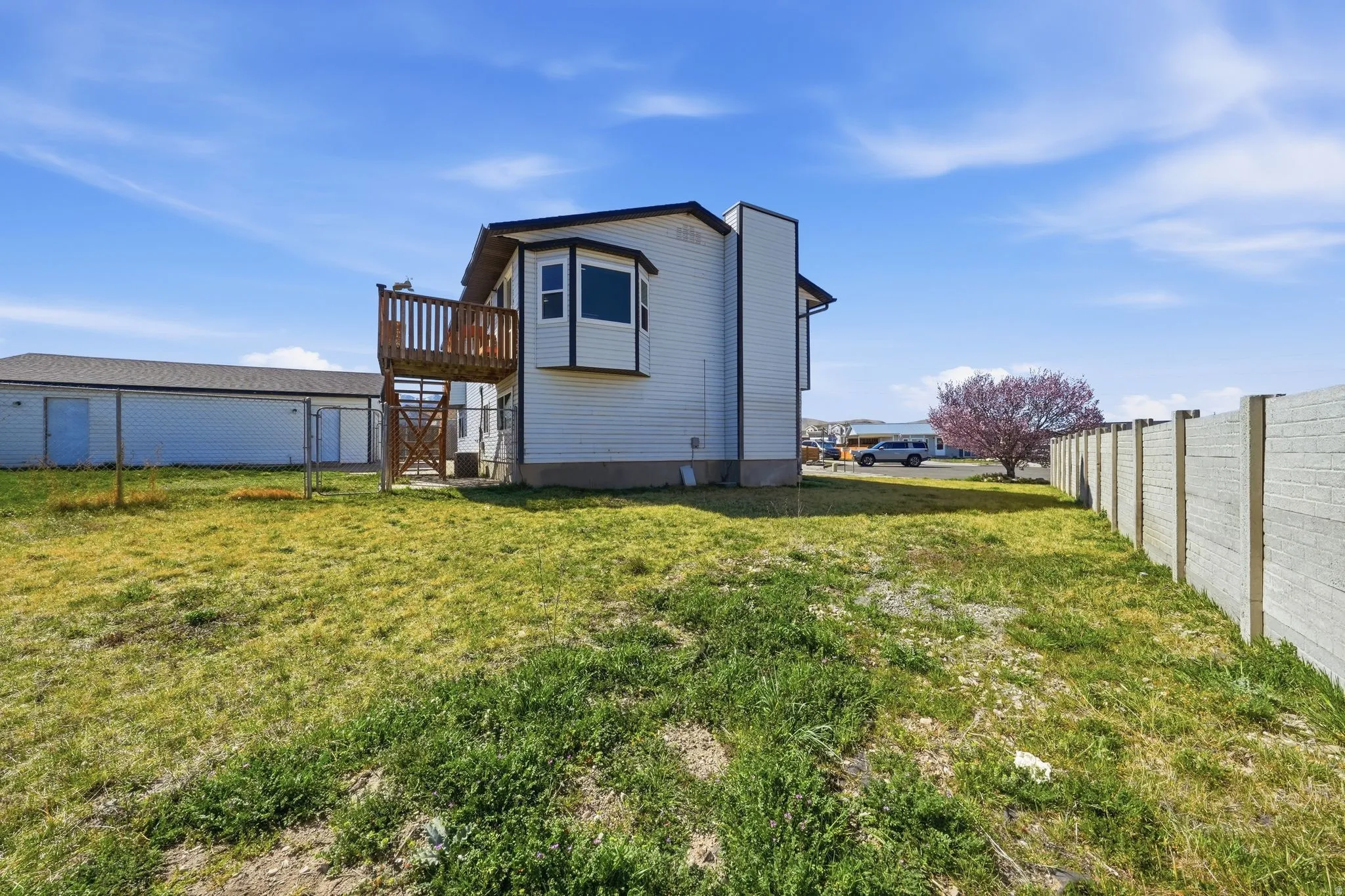 Back of property featuring a fenced backyard and a gate