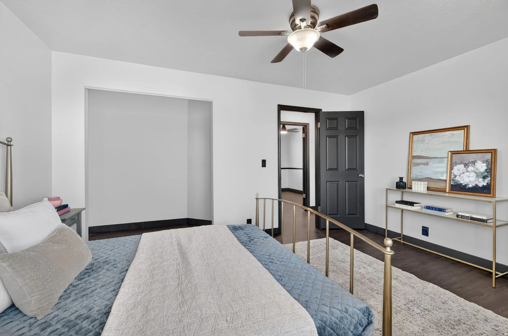 Bedroom featuring dark wood-type flooring, ceiling fan, and a closet