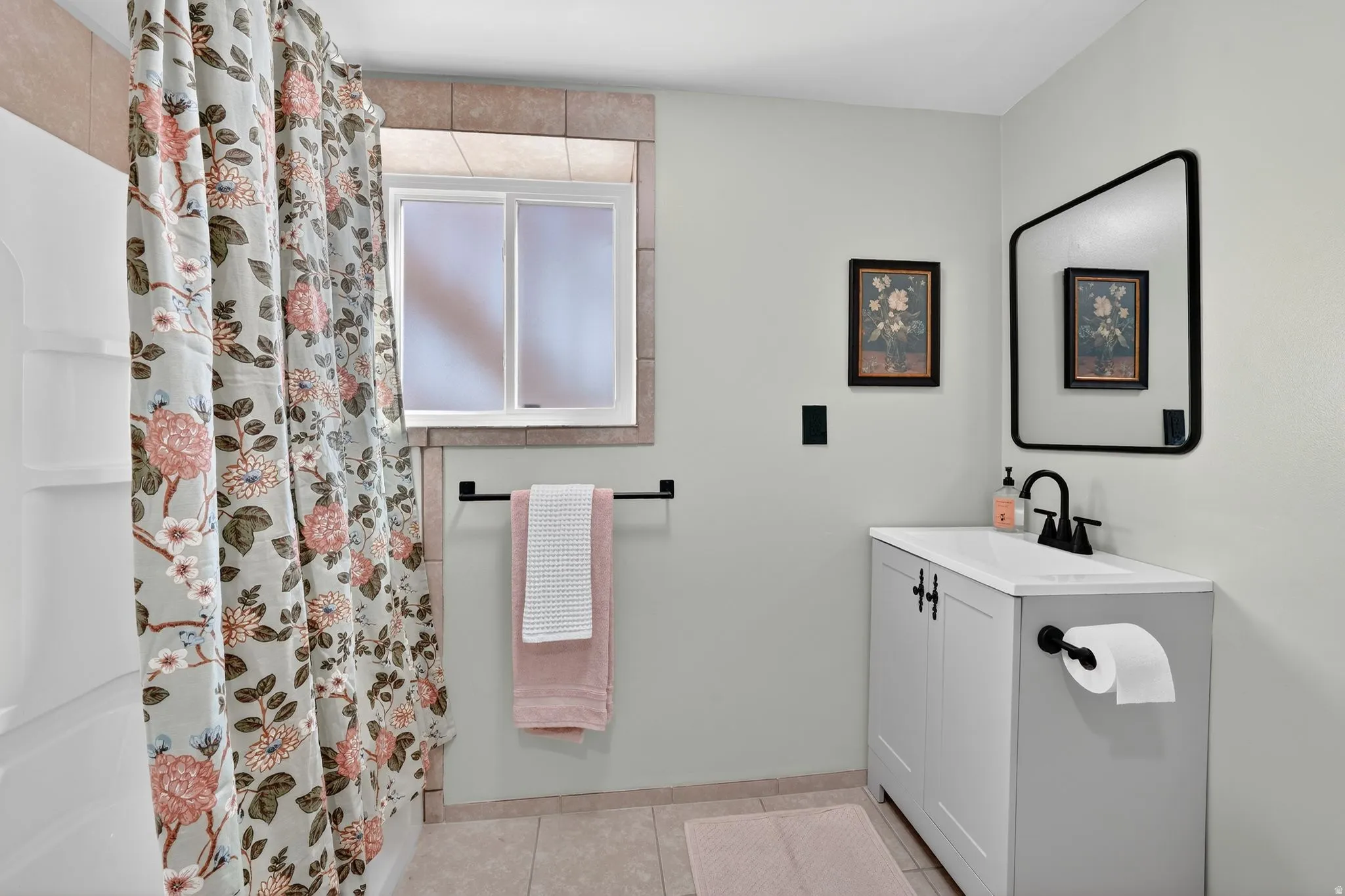 Bathroom with a shower with shower curtain, vanity, and light tile patterned floors