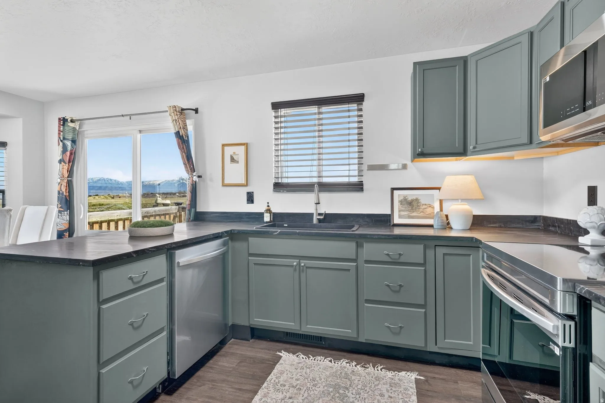 Kitchen featuring dark countertops, stainless steel appliances, and a peninsula