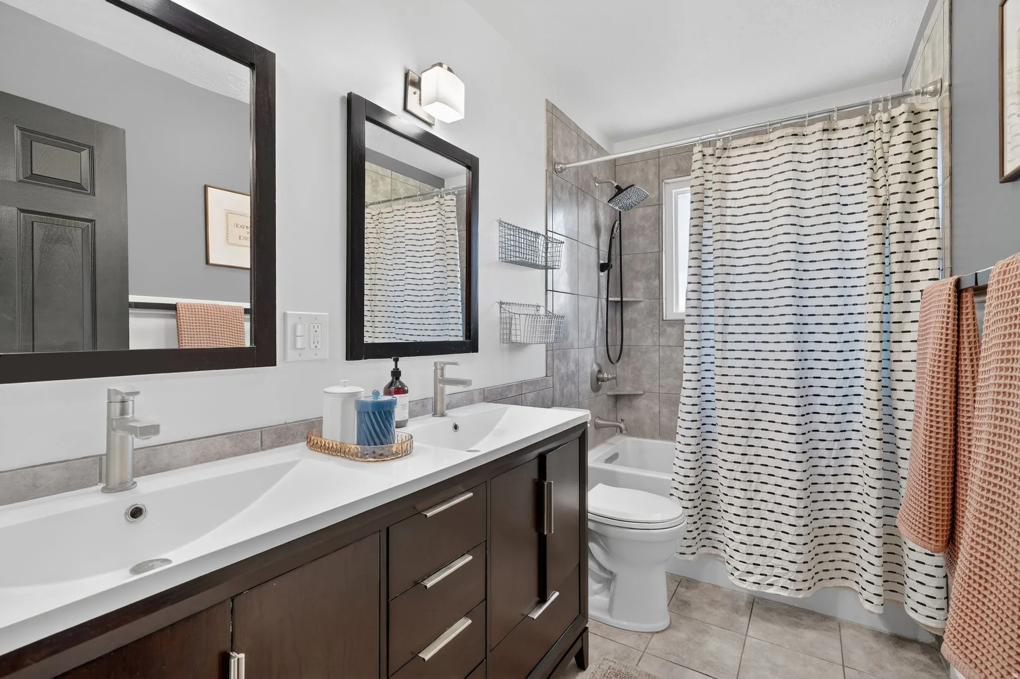 Full bathroom with shower / bath combo, double vanity, and light tile patterned flooring