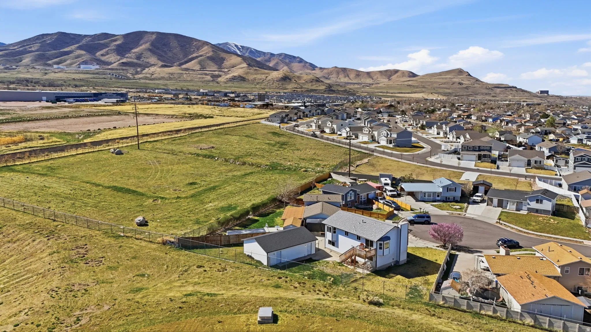 Aerial view of property's location featuring a mountain backdrop and nearby suburban area