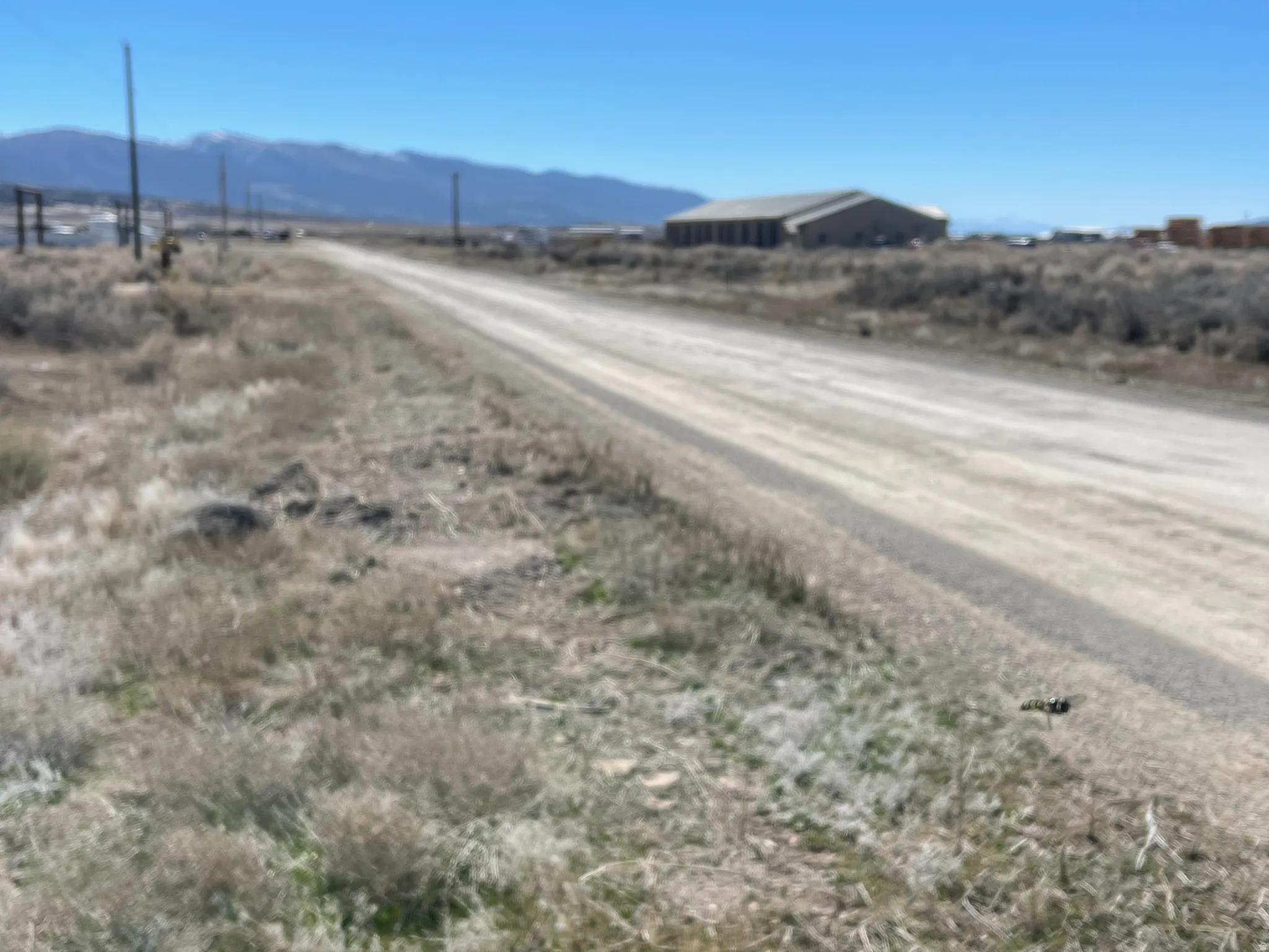 View of dirt / gravel road with a mountain view and a rural view