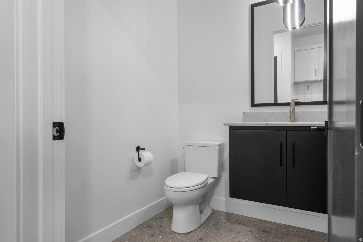 Half bath with baseboards and vanity