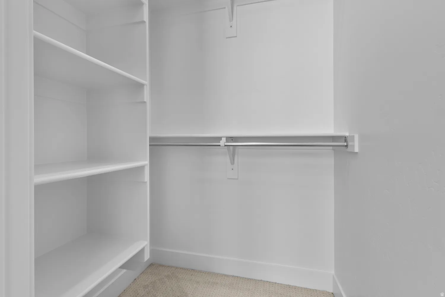 Walk in closet with light carpet