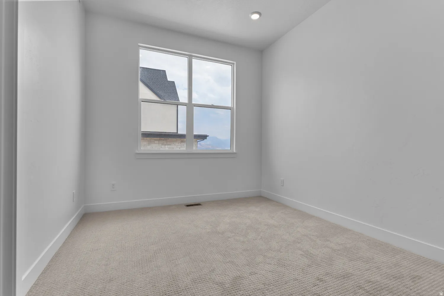 Spare room with light colored carpet and baseboards