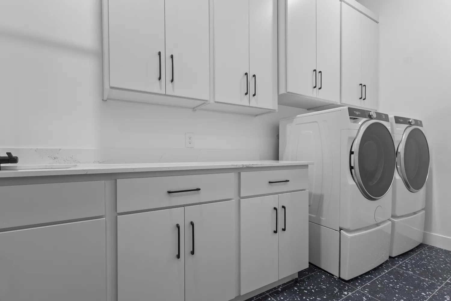 Laundry area with washer and clothes dryer, cabinet space, and dark floors