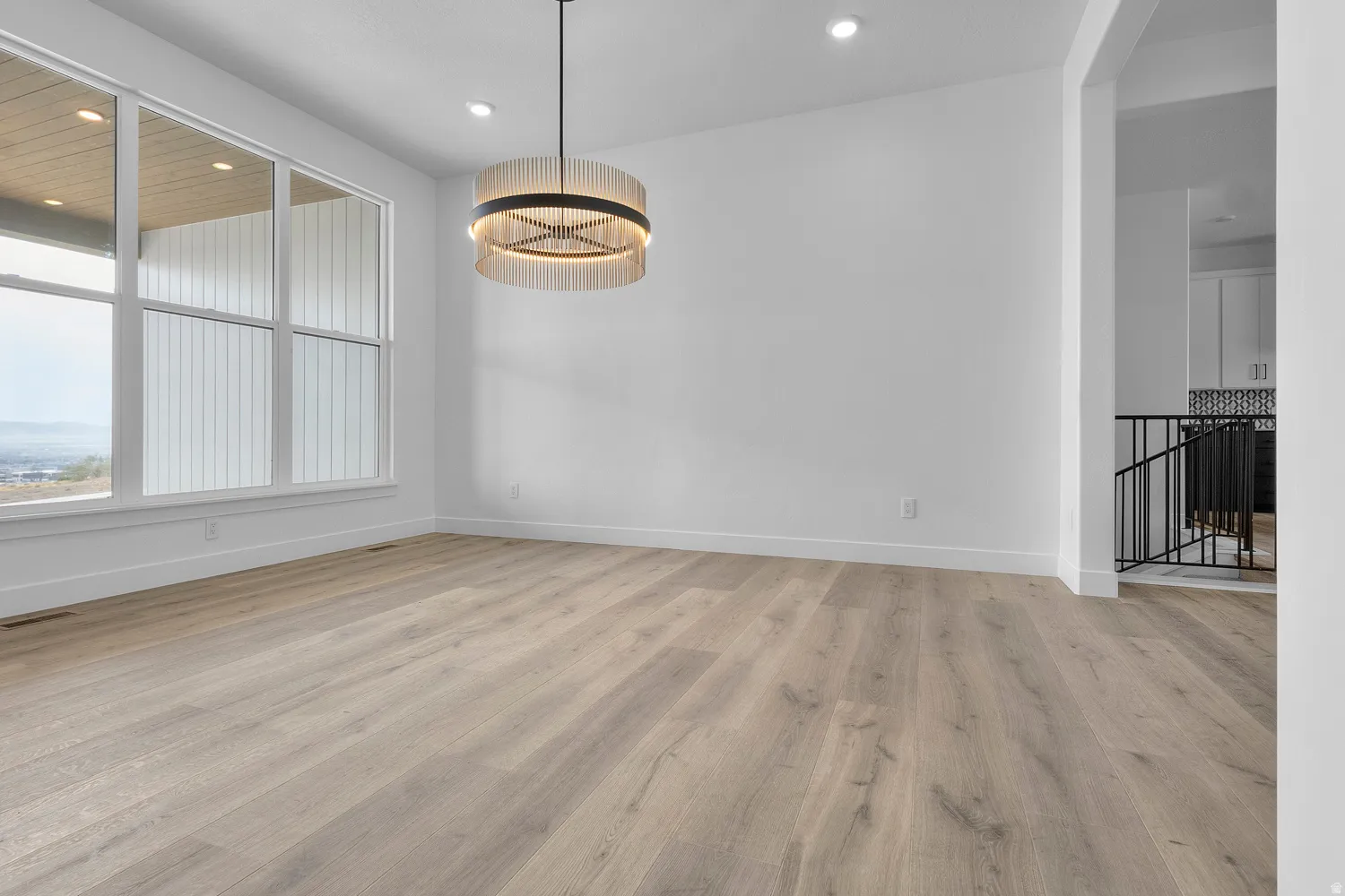 Unfurnished dining area with light wood-type flooring and hanging lights