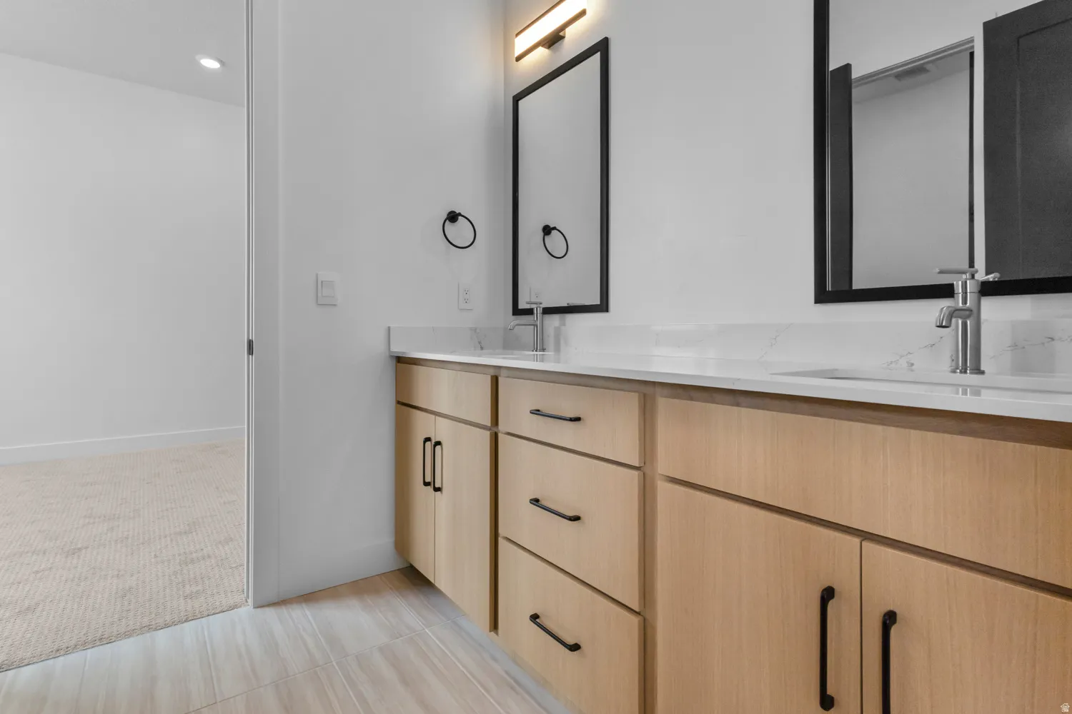 Full bath with double vanity, light carpet, and recessed lighting