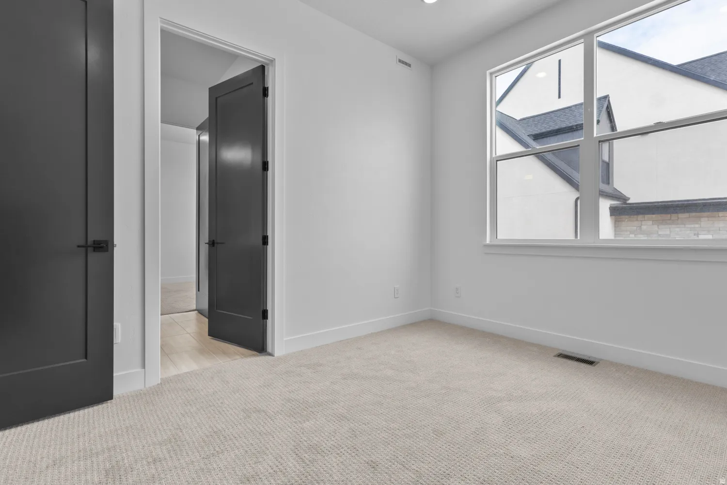 Unfurnished bedroom featuring light colored carpet and baseboards