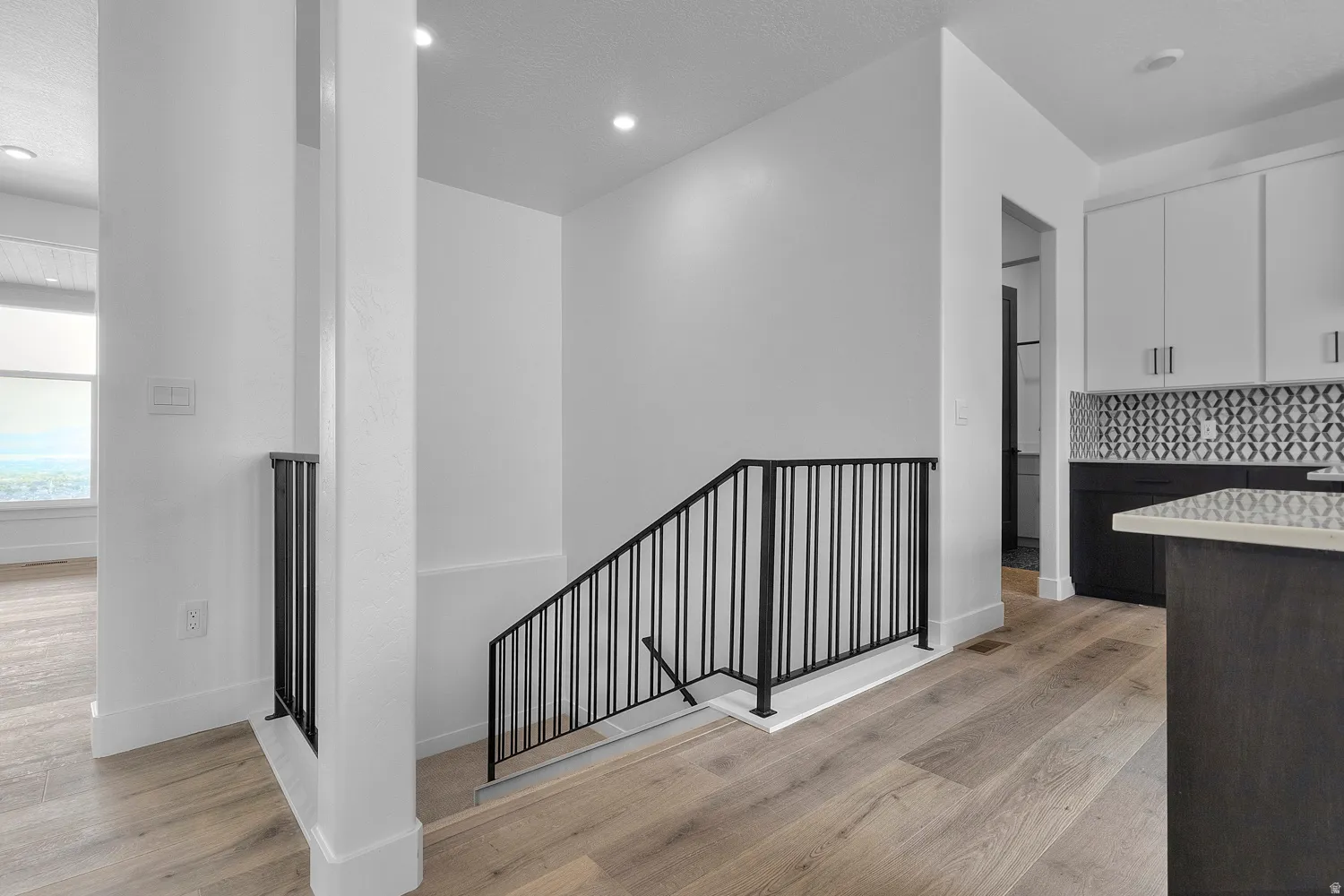 Stairs with wood finished floors and recessed lighting