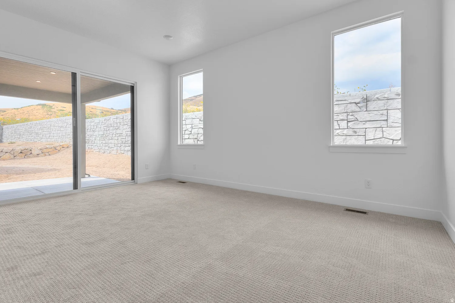 Unfurnished room with light colored carpet and baseboards