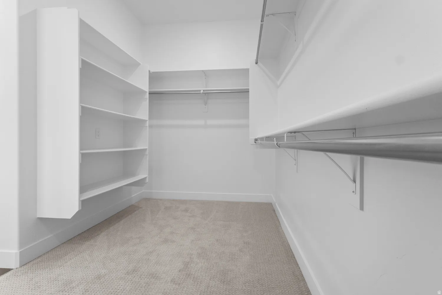 Walk in closet featuring light colored carpet