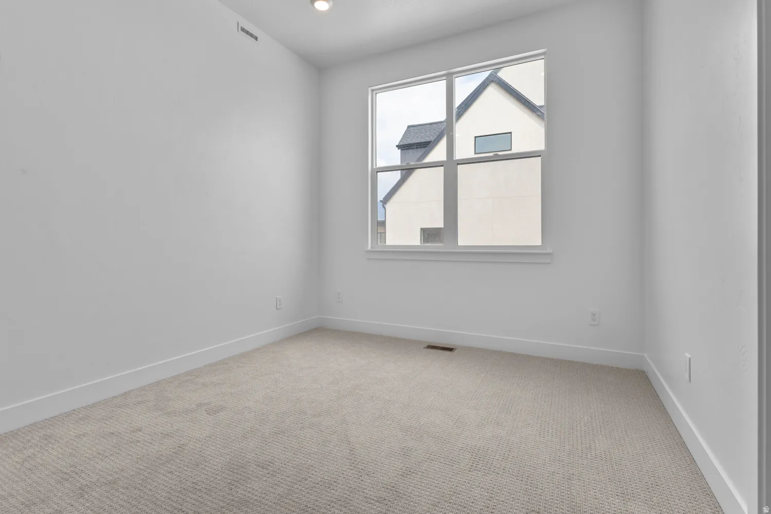 Spare room featuring light colored carpet and recessed lighting