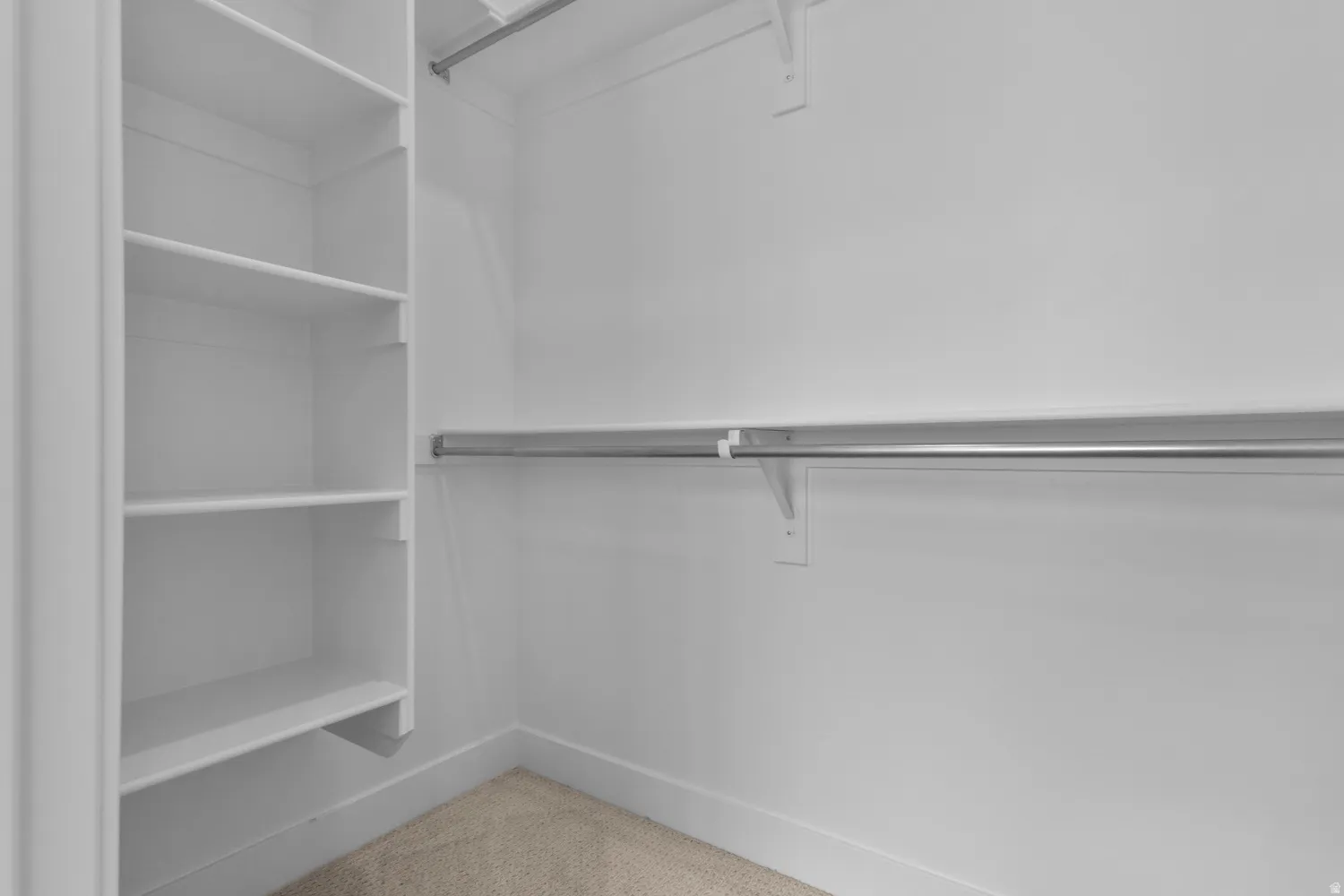 Walk in closet with light colored carpet