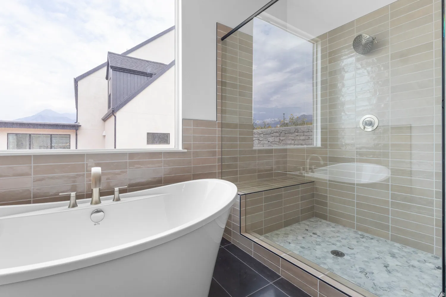 Full bathroom featuring tile walls, a freestanding tub, and a stall shower