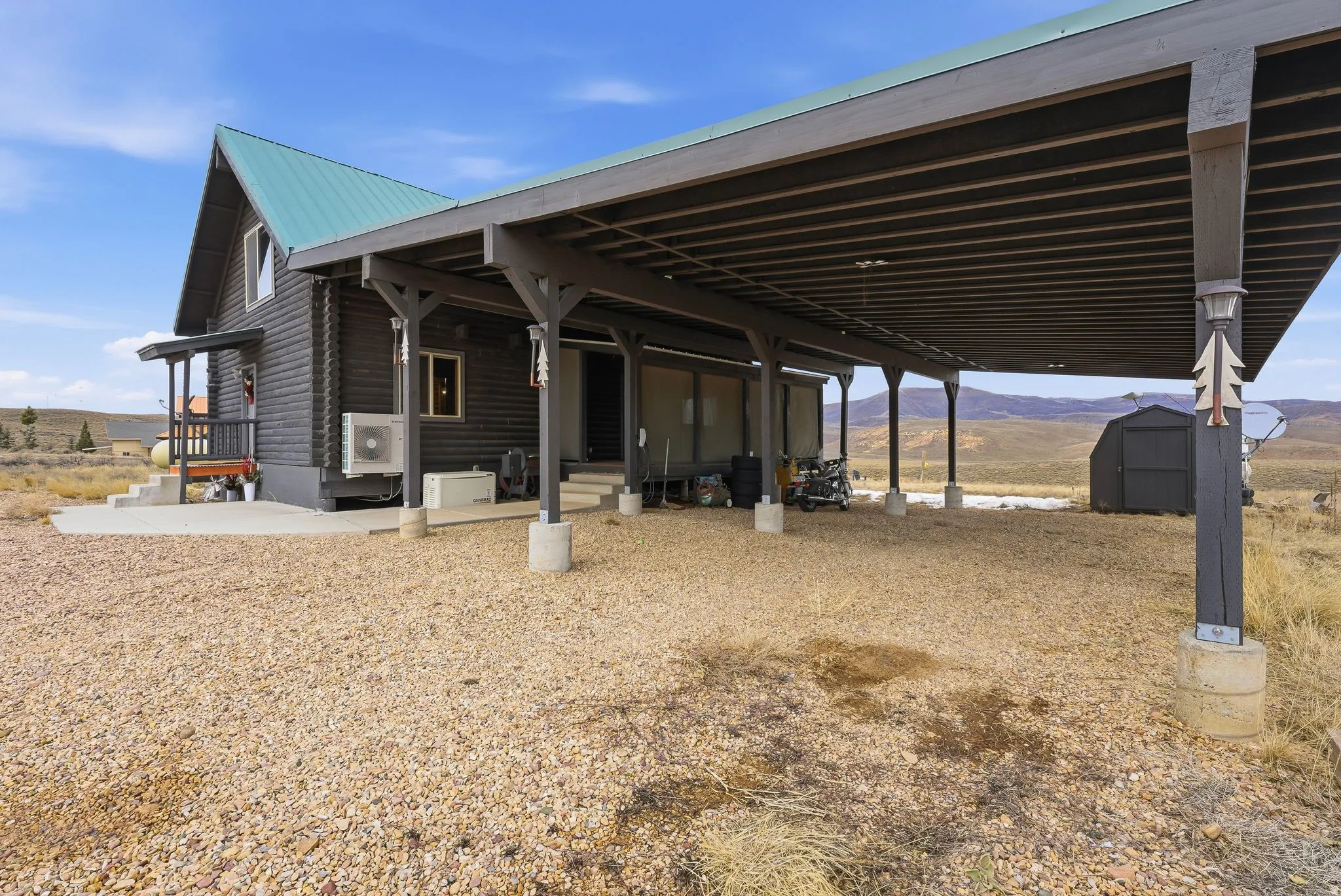 View of front of property featuring a carport, a storage shed, a metal roof, and a porch