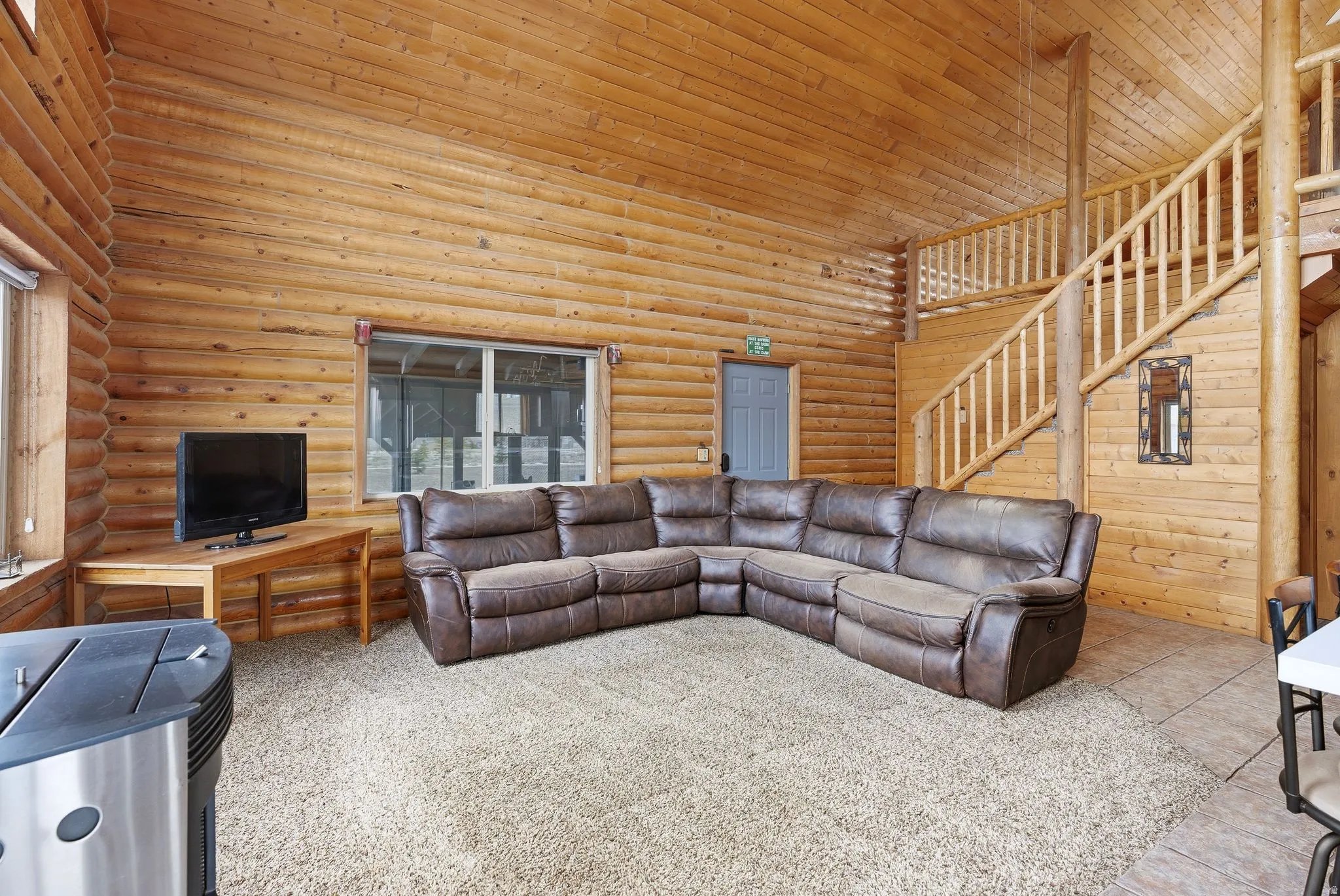 Living room featuring a high wooden ceiling and rustic walls