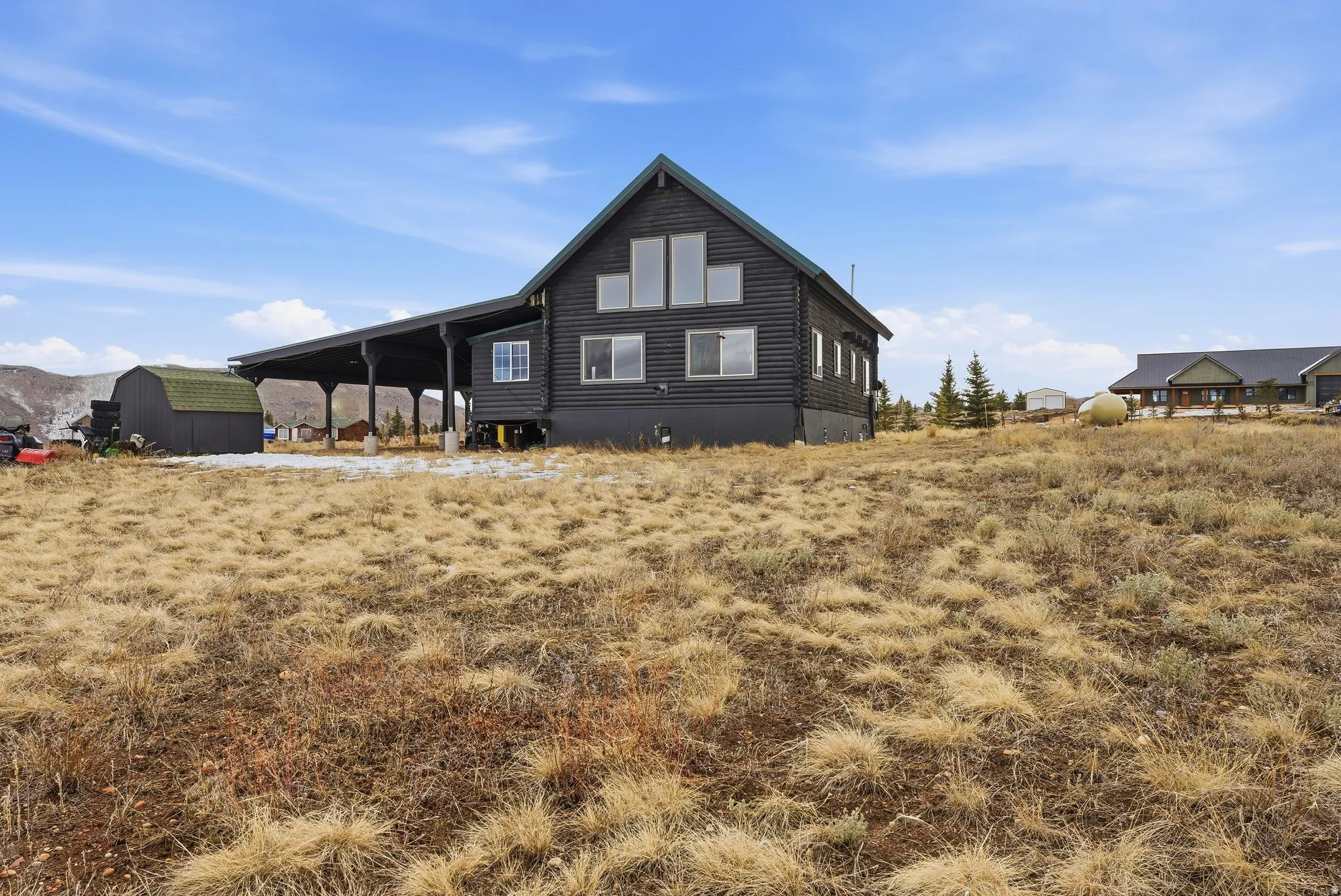 Rear view of property with an outbuilding and a carport