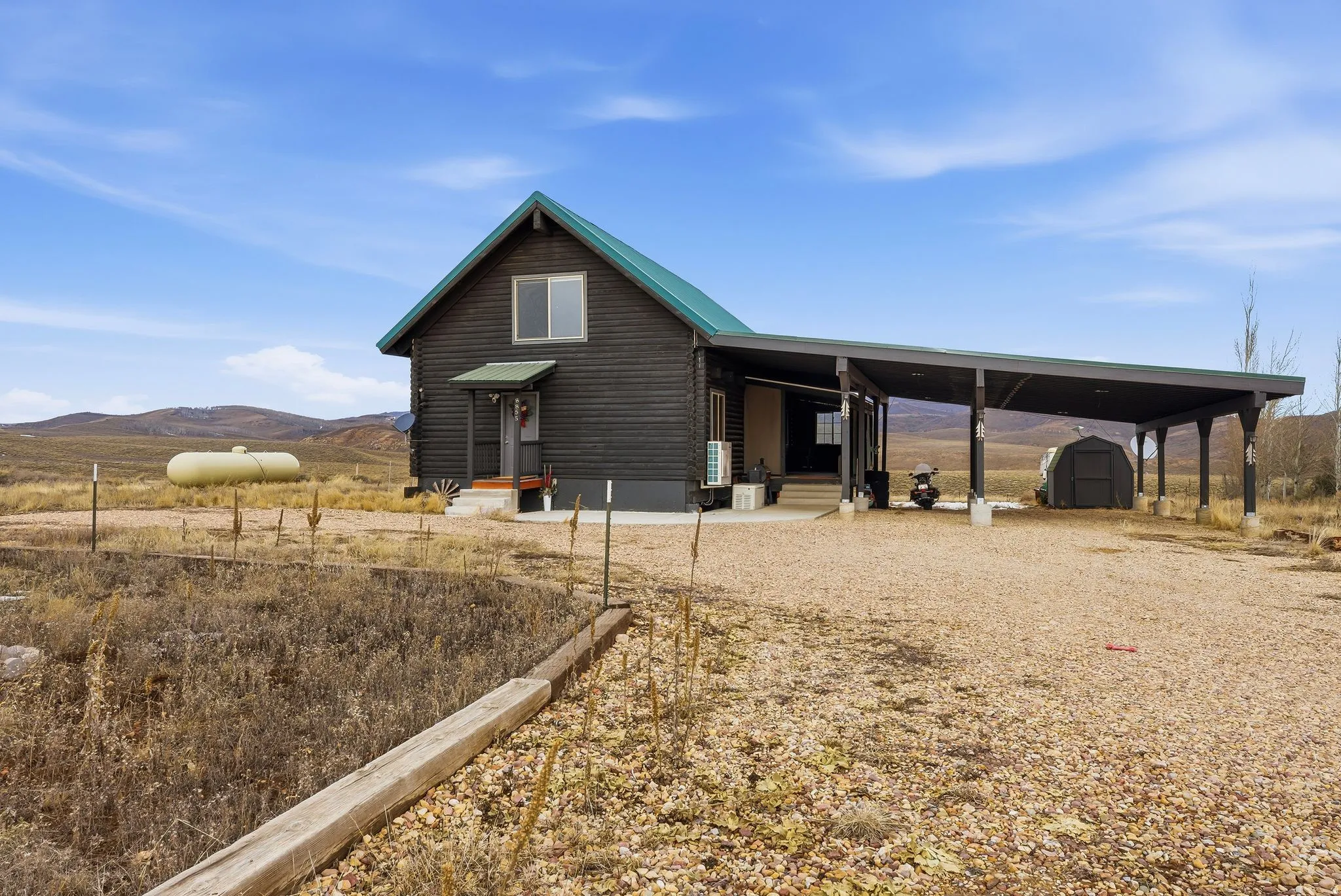 View of shed featuring a mountain view, entry steps, a carport, and a view of countryside