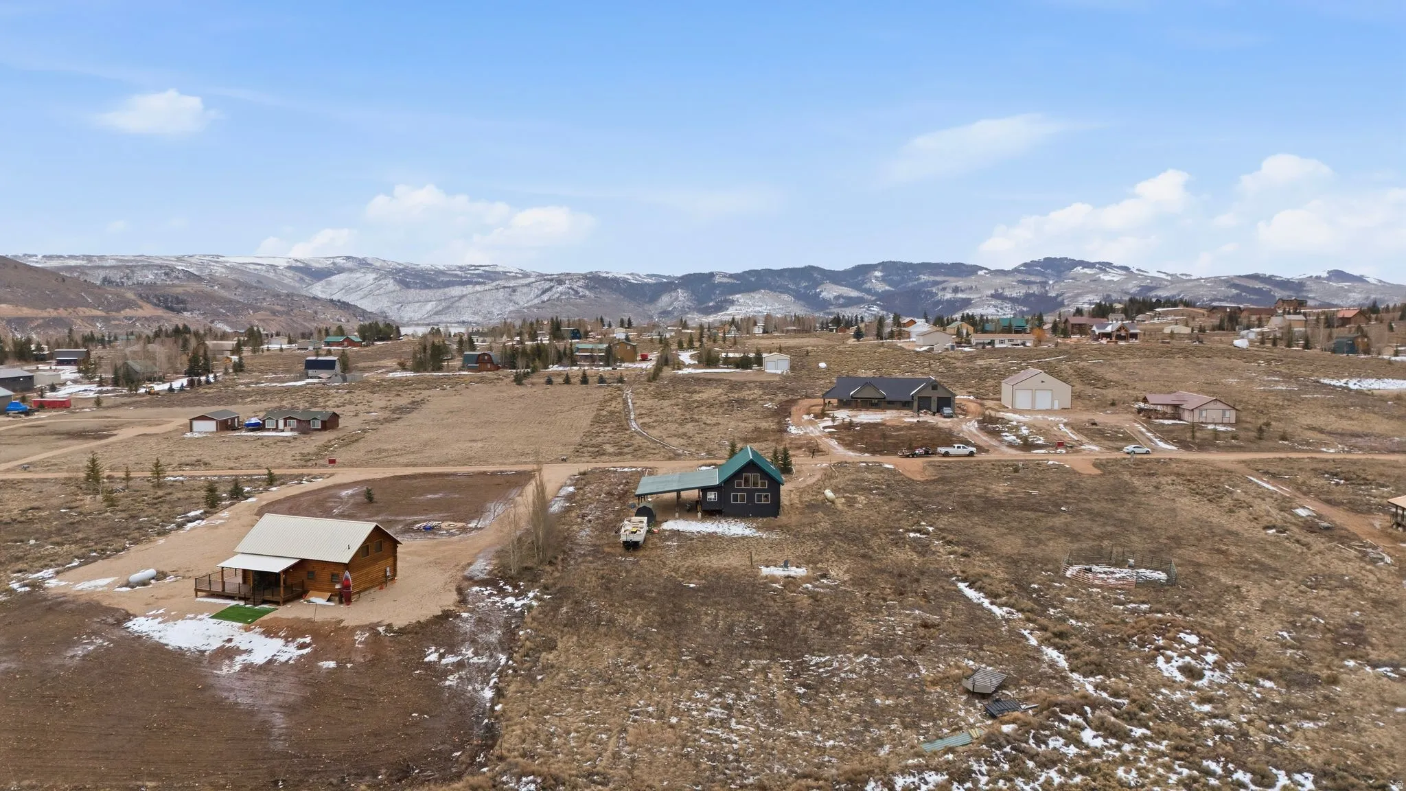 Aerial view of property's location with a mountain backdrop and nearby suburban area