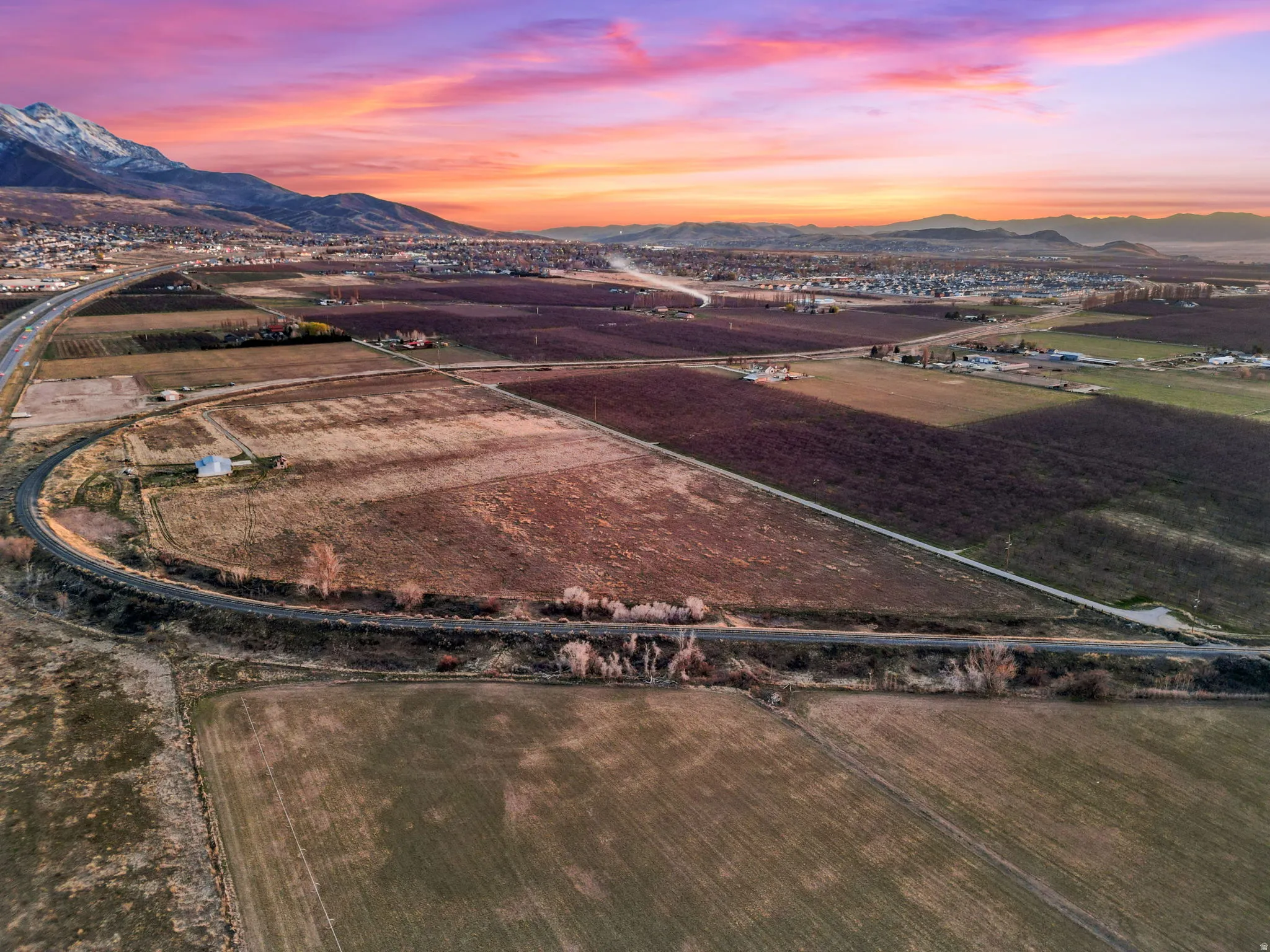 Aerial view of sparsely populated area with abundant farmland and a mountain backdrop