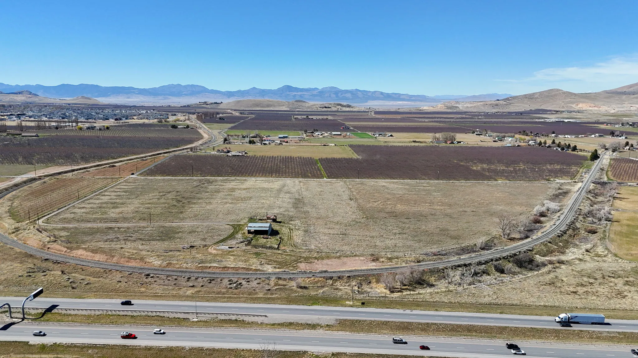 Aerial view of property and surrounding area with rural landscape, farmland, and a mountain backdrop