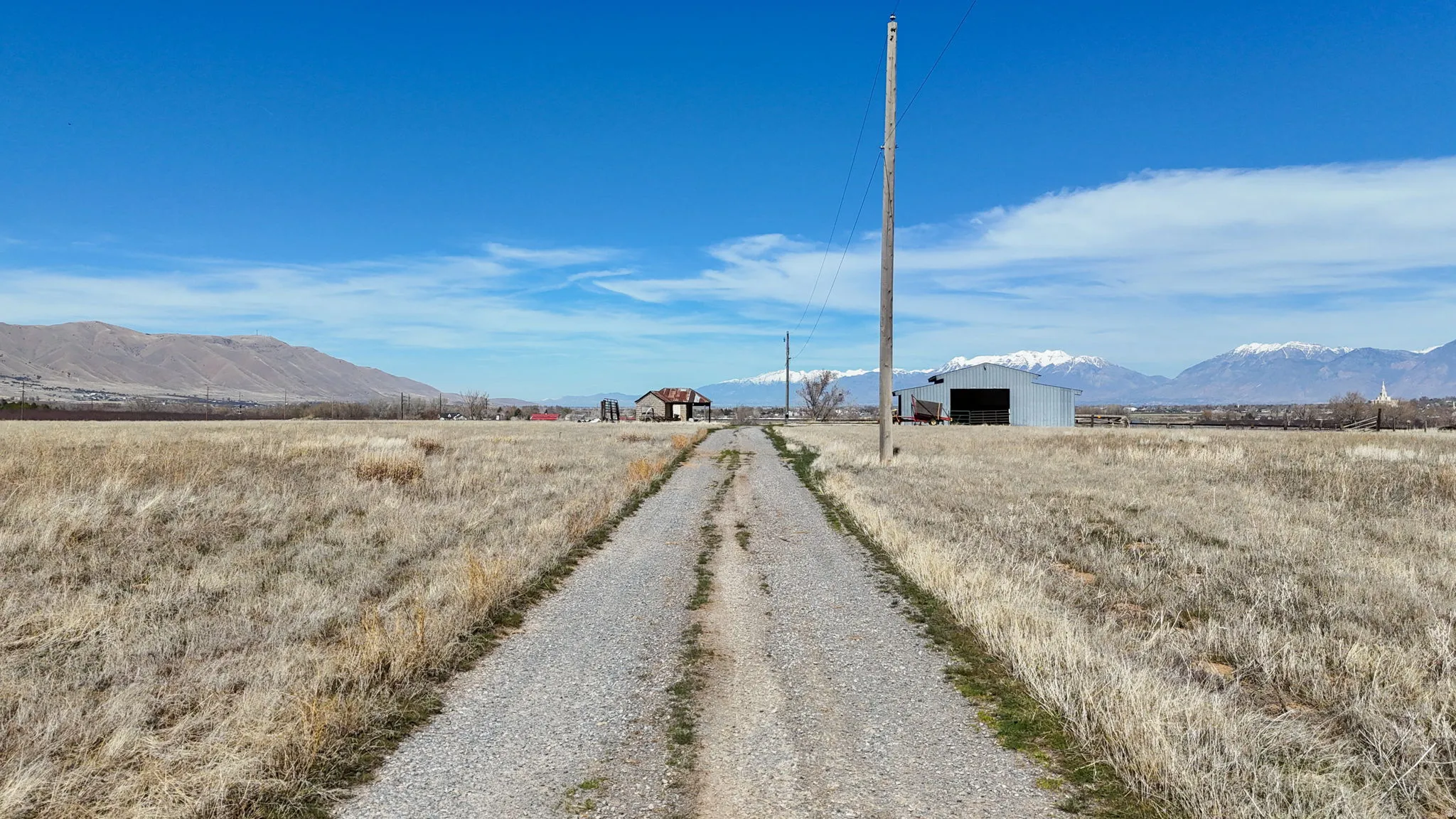 View of road featuring a mountain view, a pole building, and a view of rural / pastoral area