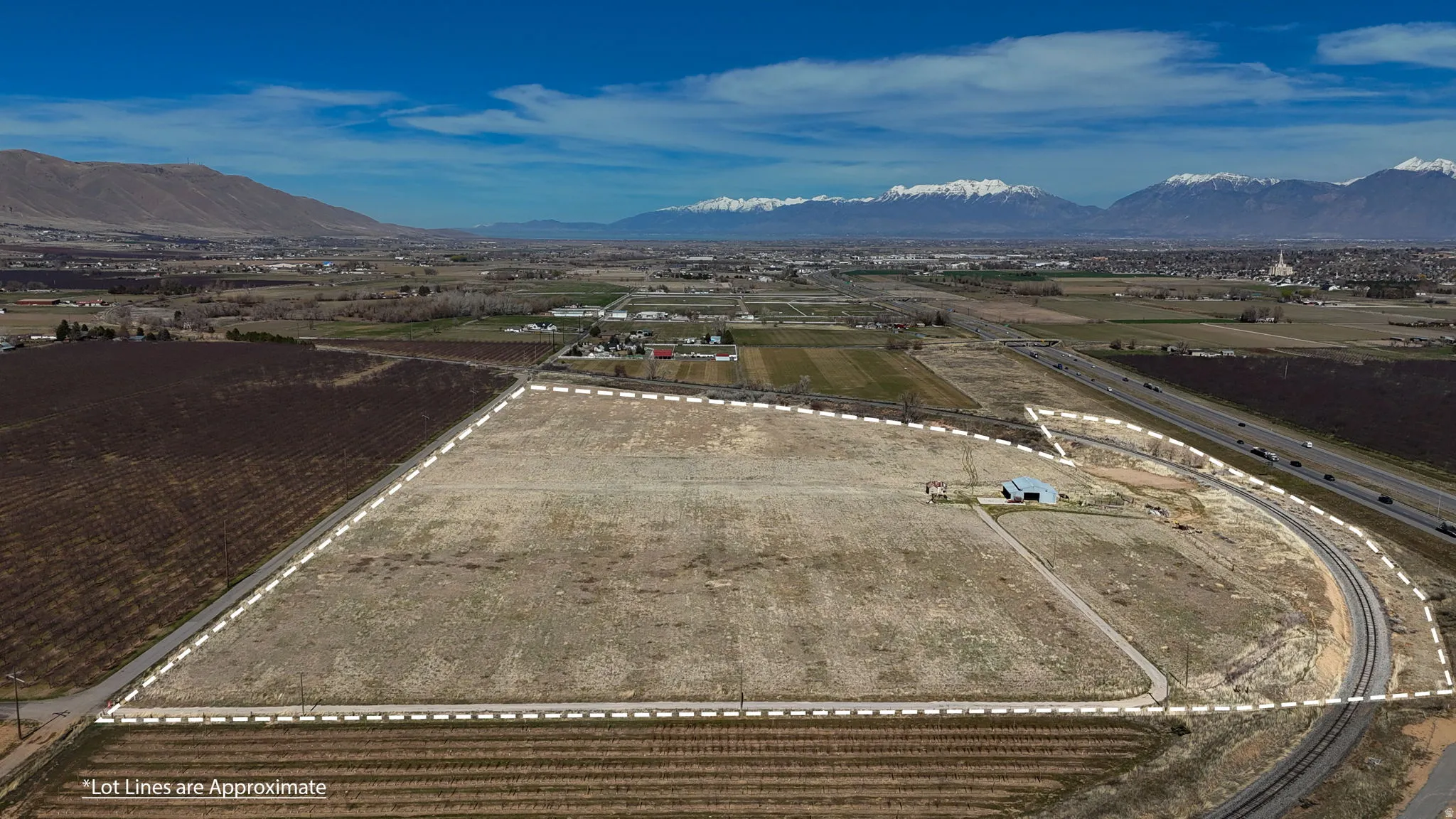 Aerial view of sparsely populated area with large plots for crops and a mountain backdrop