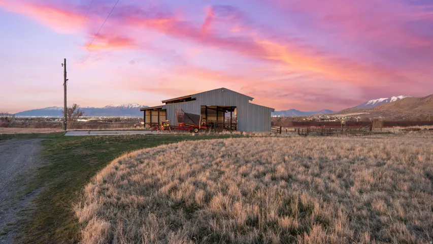 Outdoor structure at dusk with a mountain view, an outbuilding, and a rural view