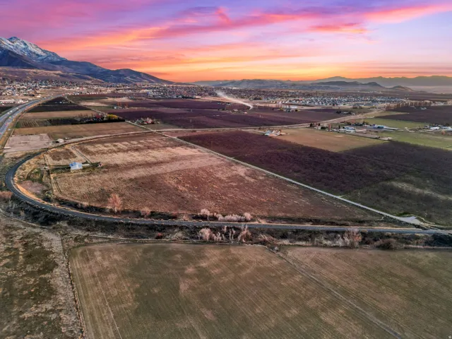 Aerial view of sparsely populated area with abundant farmland and a mountain backdrop