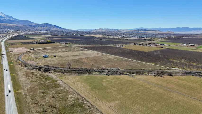 Aerial view of property's location featuring rural landscape, a mountainous background, and farmland