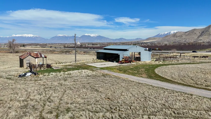 View of yard with an outbuilding, a pole building, a mountain view, a sunroom, and a rural view