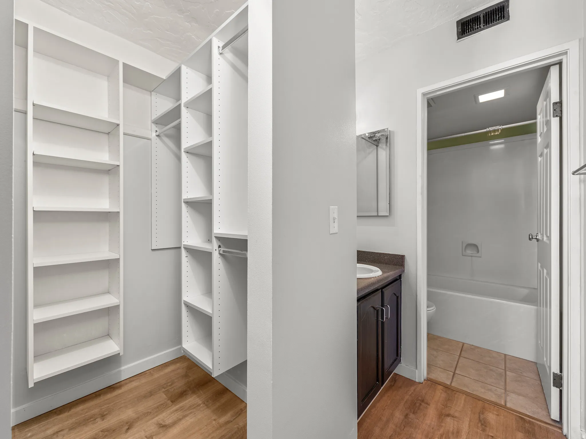 Walk in closet with light wood finished floors