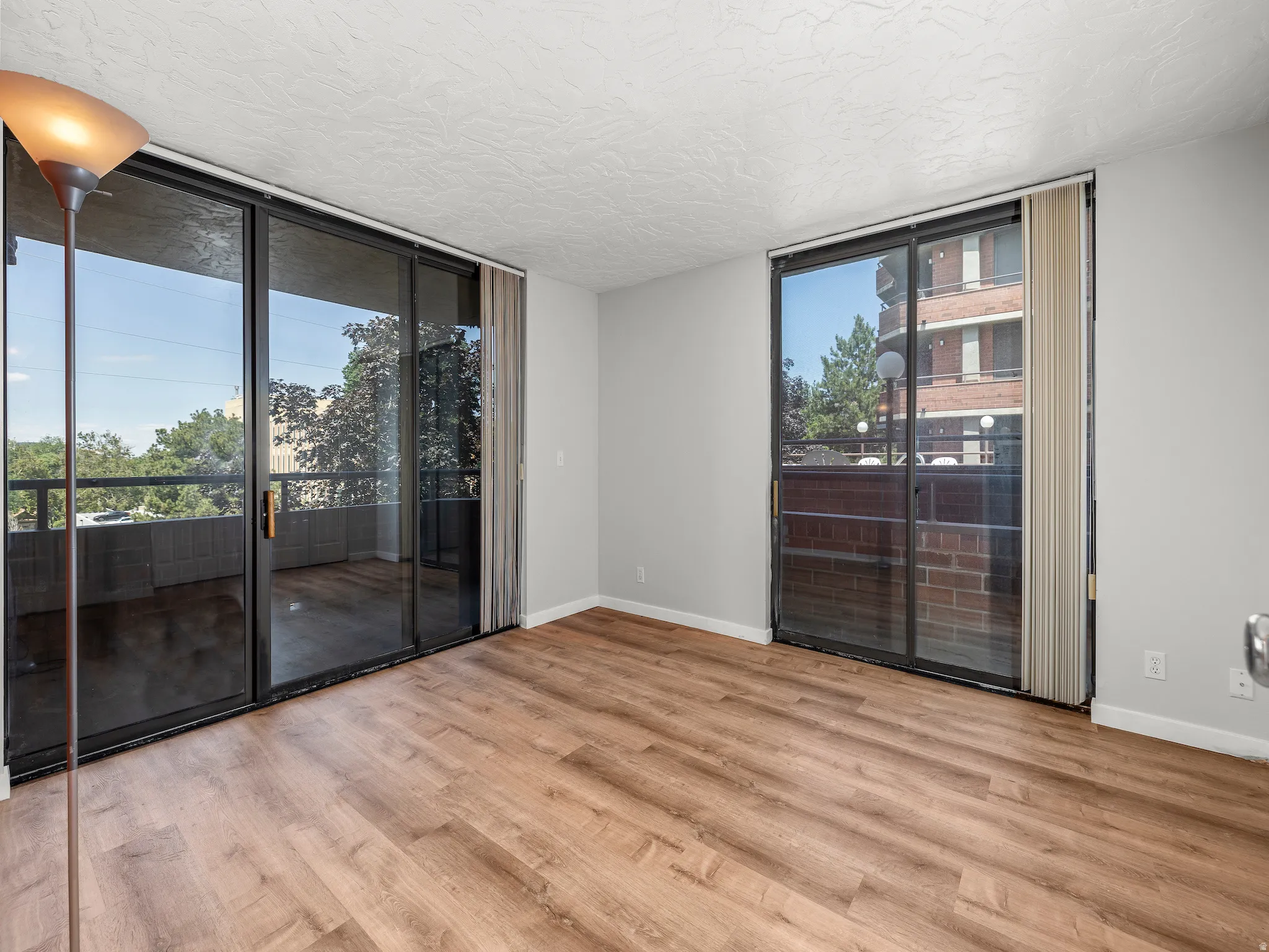 Empty room featuring floor to ceiling windows and light wood-style floors