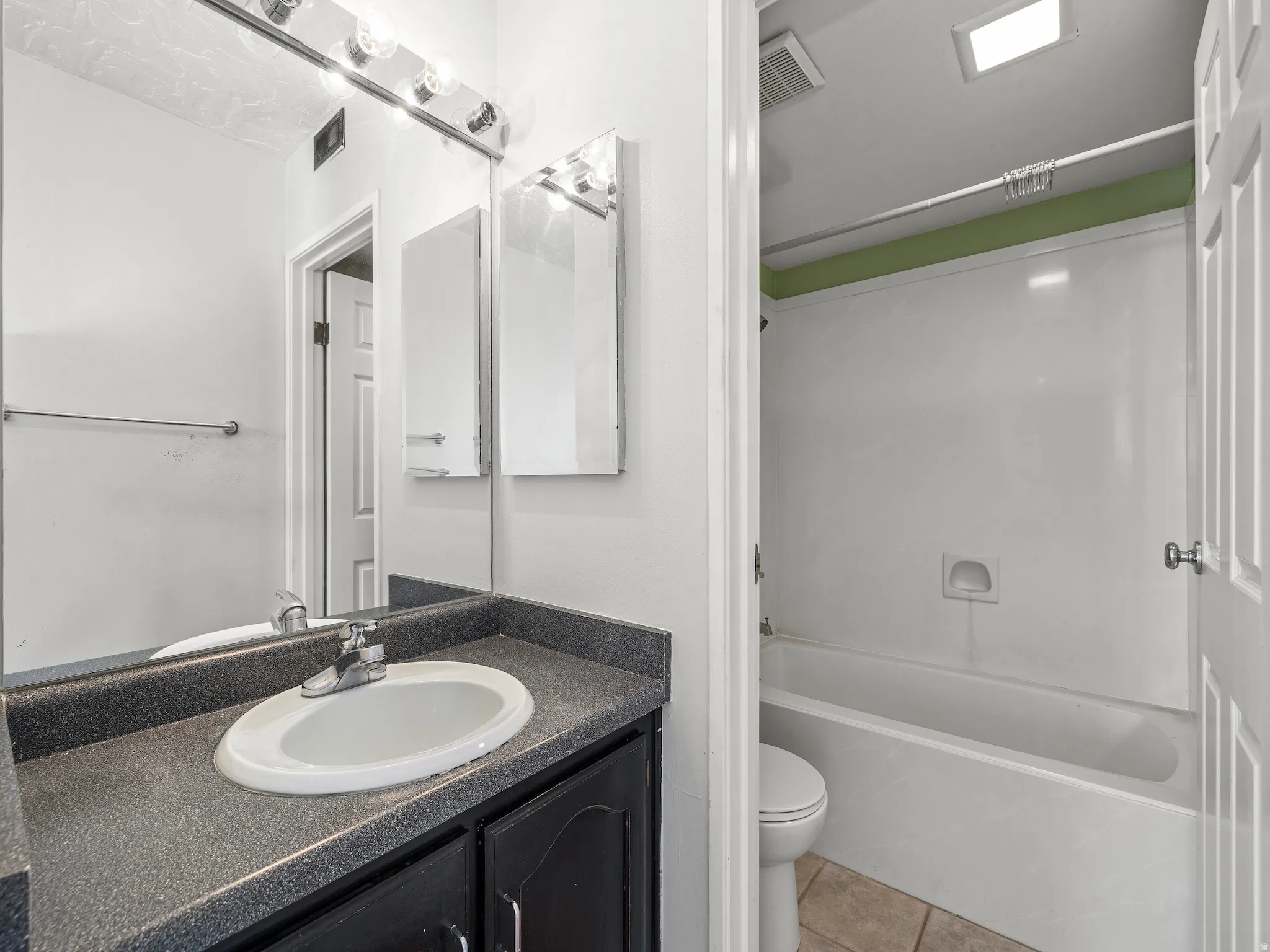 Full bathroom featuring vanity, tub / shower combination, and light tile patterned floors