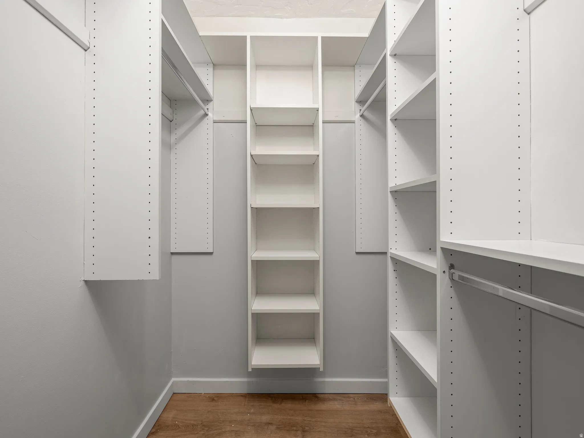 Walk in closet featuring dark wood-type flooring