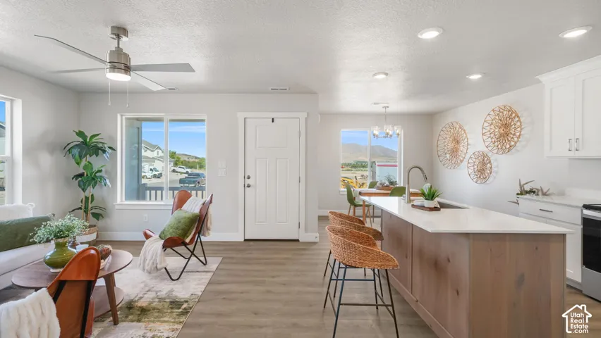 Open-concept living space featuring wood-finish flooring, recessed lighting, and a contemporary ceiling fan