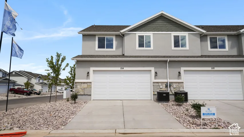 Contemporary townhome with a stucco exterior and stone accent detailing