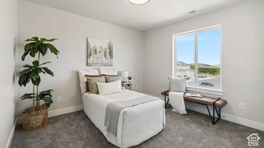 Bright room featuring a large window, neutral wall paint, and gray carpet flooring