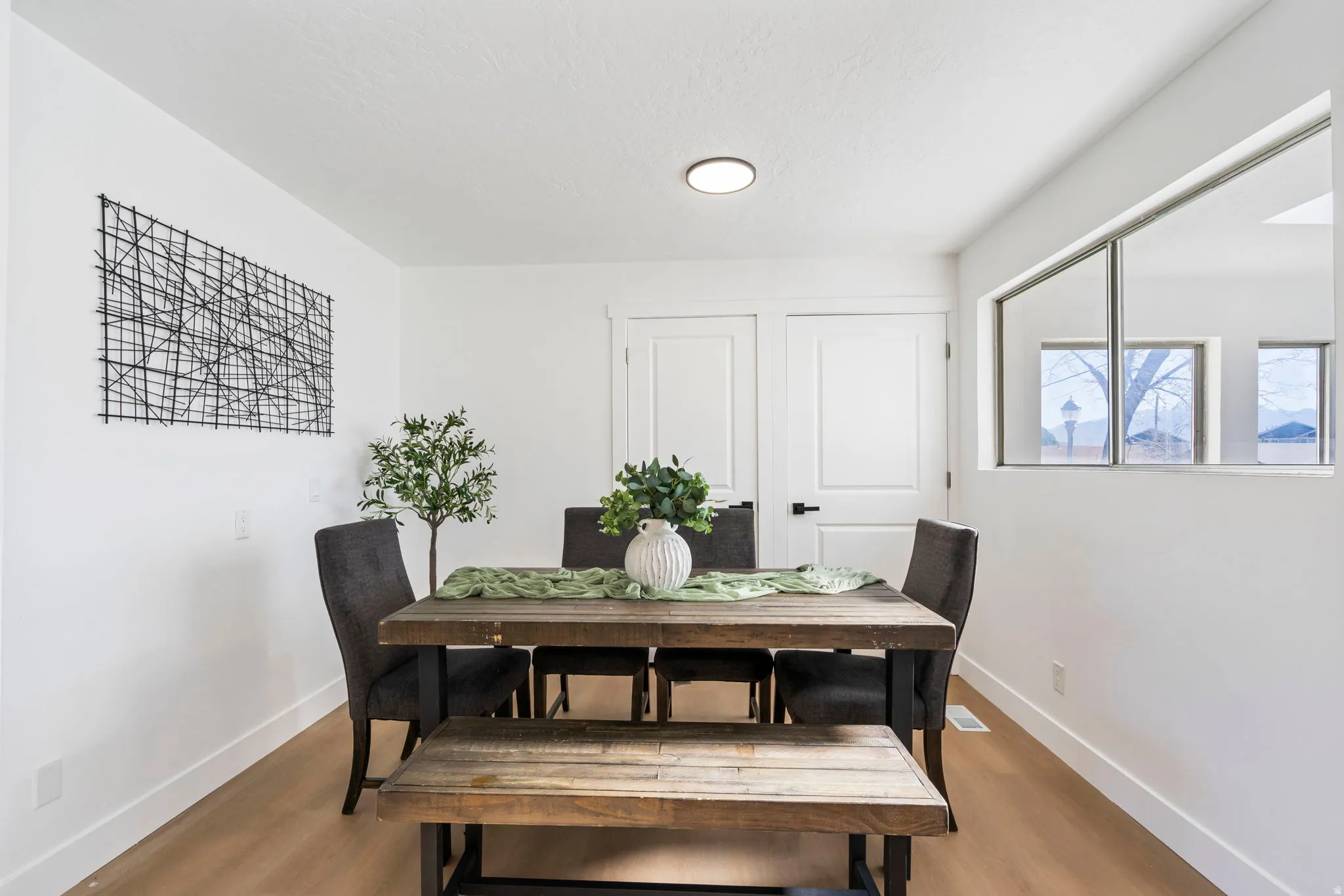 Dining space featuring light wood-style flooring and baseboards