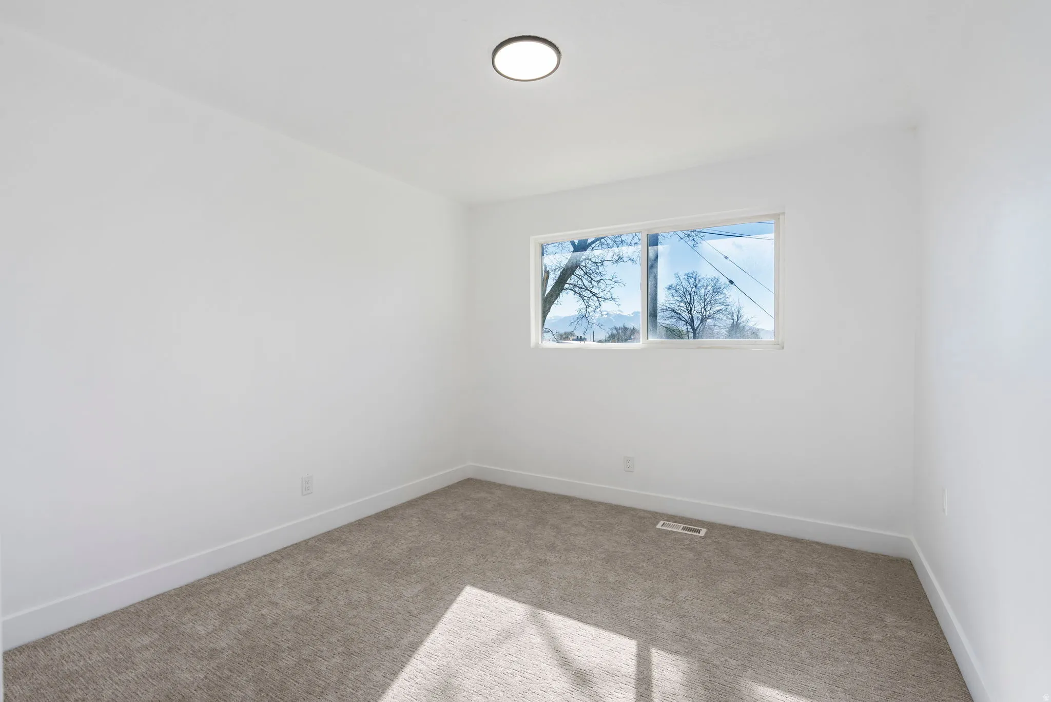 Carpeted empty room featuring baseboards