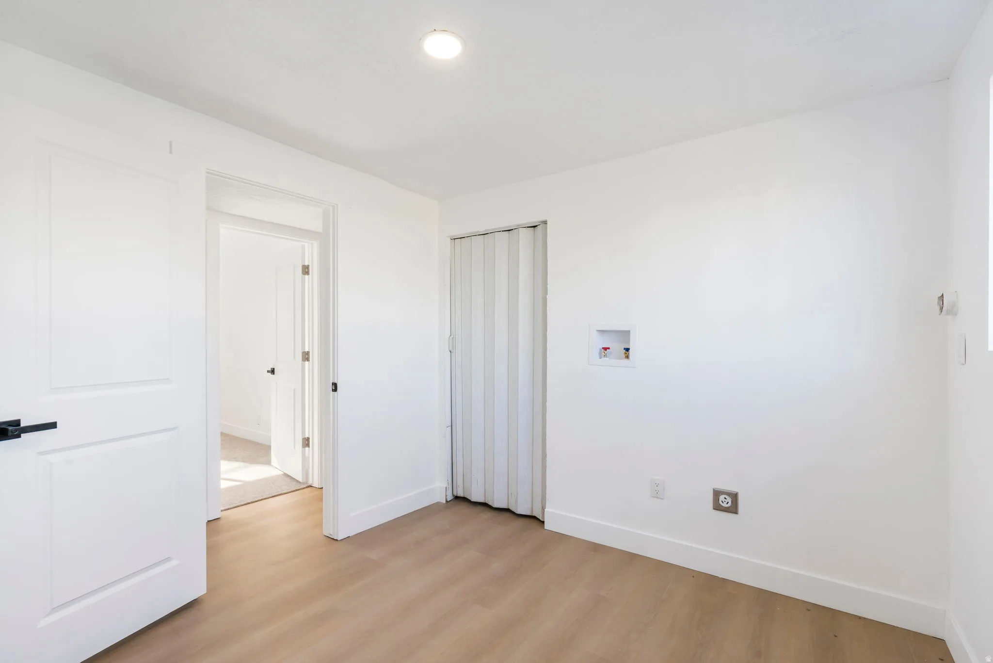 Unfurnished bedroom featuring light wood-style floors and baseboards