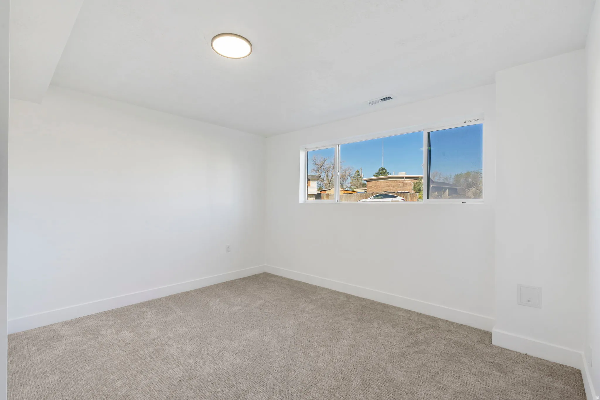 Carpeted spare room with baseboards