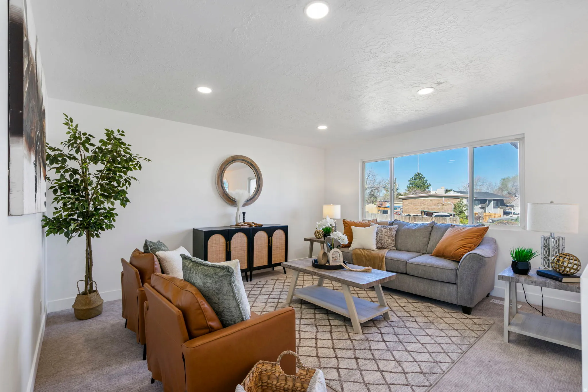 Living room with light colored carpet, a textured ceiling, and recessed lighting