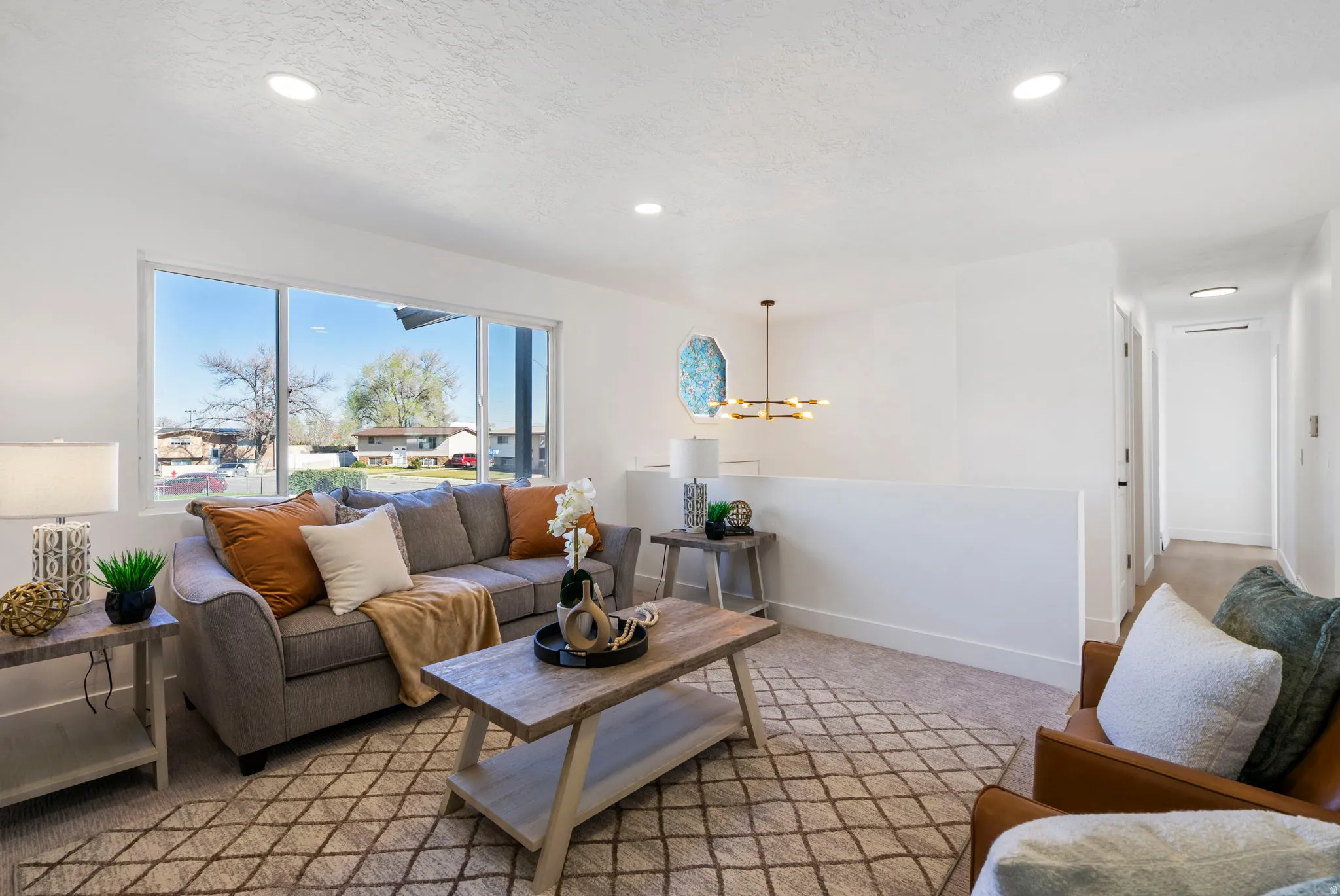 Living room featuring light carpet and a chandelier
